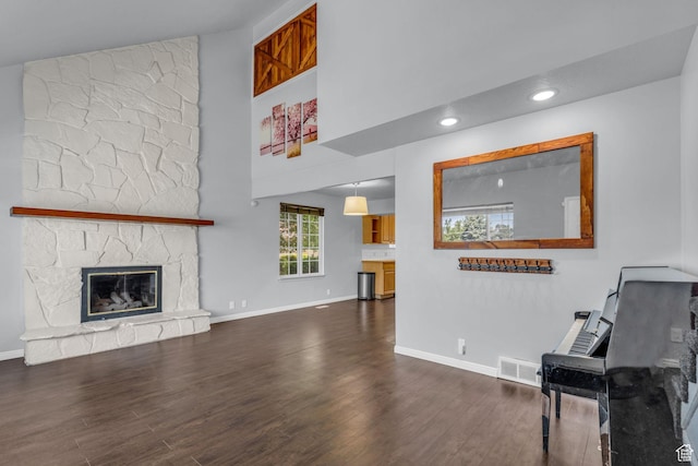 648 E 6870 S, Midvale, UT 84047 - living area with wood finished floors, a towering ceiling, baseboards, a stone fireplace, and recessed lighting