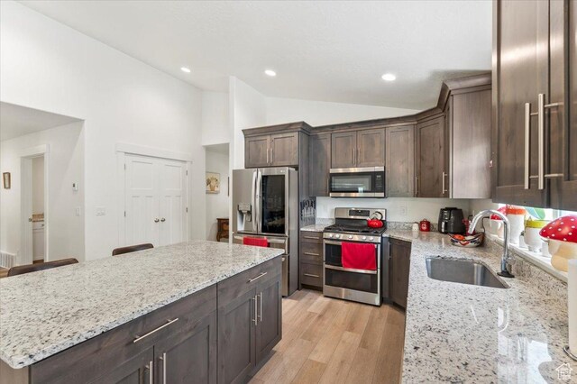 116 E 970 N, Santaquin, UT 84655 - kitchen featuring stainless steel appliances, a sink, vaulted ceiling, dark brown cabinetry, and light stone countertops
