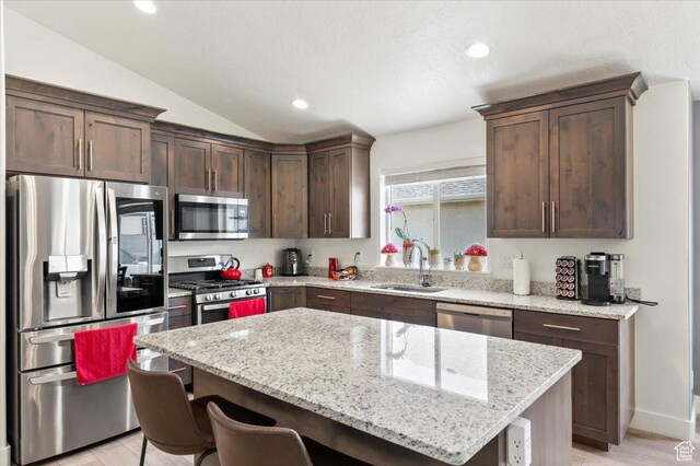 116 E 970 N, Santaquin, UT 84655 - kitchen with stainless steel appliances, a sink, dark brown cabinets, a breakfast bar, and a kitchen island