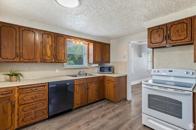 106 N 400 E, Kaysville, UT 84037 - kitchen featuring white electric range, dishwasher, stainless steel microwave, light wood finished floors, and brown cabinetry