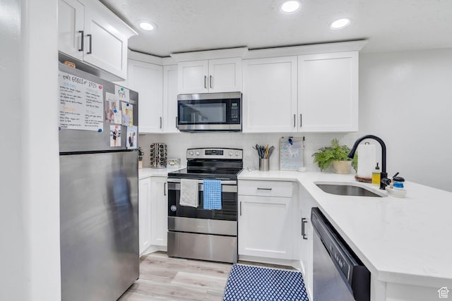 162 W 350 N, Vineyard, UT 84059 - kitchen with appliances with stainless steel finishes, a sink, a peninsula, light wood-style floors, and recessed lighting