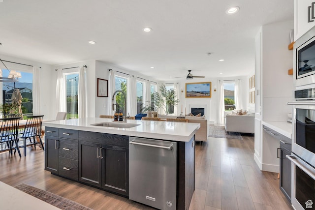 162 W 350 N, Vineyard, UT 84059 - kitchen featuring stainless steel appliances, a sink, light countertops, a fireplace, and ceiling fan