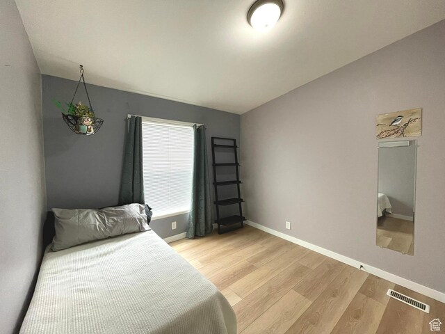 870 S 100 E, Wellington, UT 84542 - bedroom featuring baseboards, light wood-style floors, and lofted ceiling