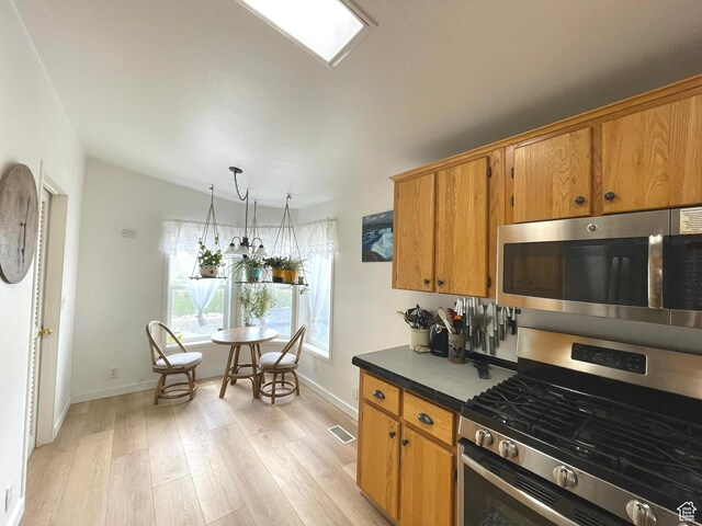 870 S 100 E, Wellington, UT 84542 - kitchen with appliances with stainless steel finishes, light wood-type flooring, brown cabinetry, and baseboards