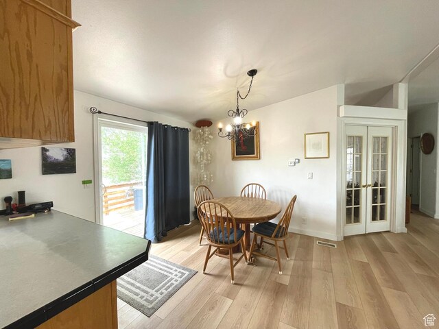 870 S 100 E, Wellington, UT 84542 - dining area featuring light wood-style flooring, a chandelier, french doors, and baseboards