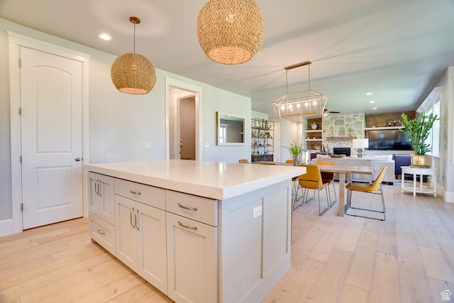 500 W Cascade Pkwy, Midway, UT 84049 - kitchen featuring light wood finished floors, a kitchen island, open floor plan, pendant lighting, and a fireplace