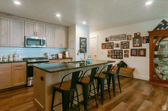 1123 S 4150 W, West Point, UT 84015 - kitchen with appliances with stainless steel finishes, a sink, dark countertops, dark wood finished floors, and tasteful backsplash