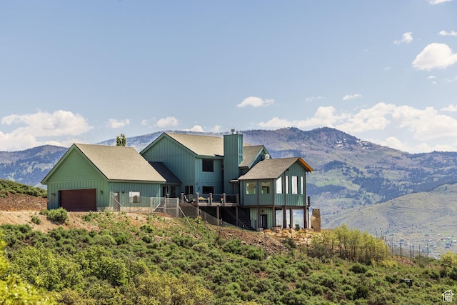 1960 Grandview Loop Unit 41, Kamas, UT 84036 - back of property featuring a garage, board and batten siding, stairway, a deck with mountain view, and a chimney