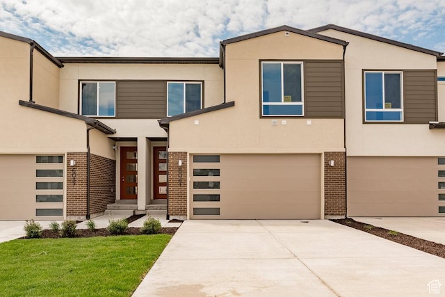 6064 W Lower Ln Unit 8-222, West Jordan, UT 84081 - view of front of property with an attached garage, stucco siding, brick siding, and a front yard