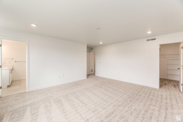 6064 W Lower Ln Unit 8-222, West Jordan, UT 84081 - unfurnished bedroom with a walk in closet, recessed lighting, light colored carpet, and a closet