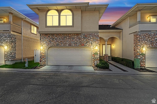 7819 S Spruce Tree Ln, Sandy, UT 84094 - view of front of house with stucco siding, concrete driveway, and stone siding