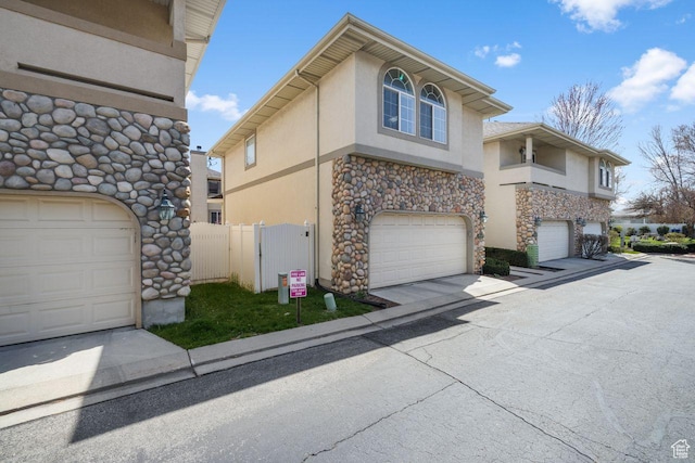 7819 S Spruce Tree Ln, Sandy, UT 84094 - view of property exterior with stucco siding, stone siding, an attached garage, and concrete driveway