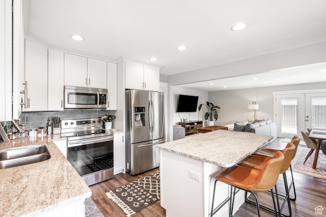 807 E Ln Dore Dr, Salt Lake City, UT 84107 - kitchen featuring stainless steel appliances, a center island, dark wood-type flooring, open floor plan, and white cabinets