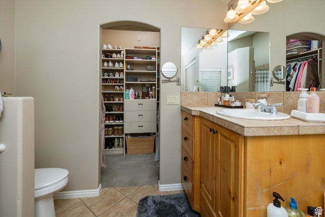 1007 E 2650 N, North Logan, UT 84341 - full bath featuring tile patterned flooring, vanity, a spacious closet, toilet, and baseboards