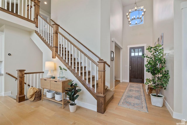 1676 W Timp Meadows Dr, Lehi, UT 84043 - foyer entrance with wood finished floors, a towering ceiling, baseboards, a chandelier, and stairs