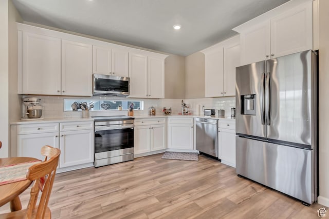 6078 W 11800 S Unit 490, South Jordan, UT 84009 - kitchen featuring appliances with stainless steel finishes, white cabinets, light countertops, tasteful backsplash, and recessed lighting