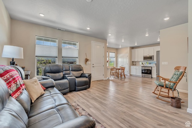 6078 W 11800 S Unit 490, South Jordan, UT 84009 - living area featuring plenty of natural light, light wood finished floors, recessed lighting, and baseboards
