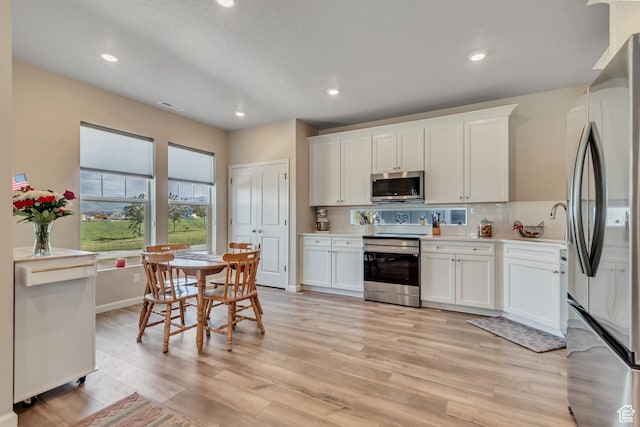 6078 W 11800 S Unit 490, South Jordan, UT 84009 - kitchen with stainless steel appliances, light countertops, light wood-style flooring, white cabinetry, and recessed lighting