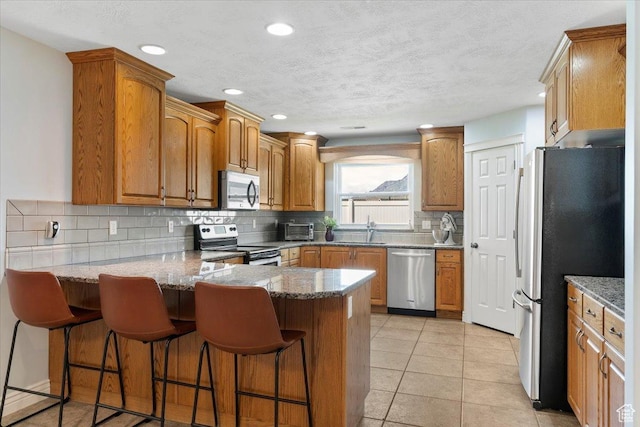 286 W 1875 N, North Ogden, UT 84414 - kitchen with appliances with stainless steel finishes, a sink, a peninsula, tasteful backsplash, and a breakfast bar area