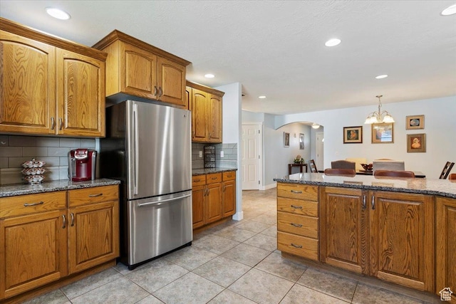 286 W 1875 N, North Ogden, UT 84414 - kitchen with freestanding refrigerator, arched walkways, brown cabinetry, tasteful backsplash, and recessed lighting
