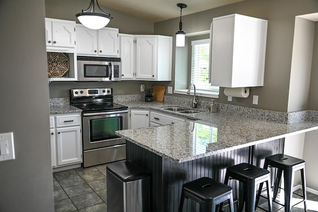 2156 E 3000 N, Layton, UT 84040 - kitchen featuring stainless steel appliances, a peninsula, a sink, white cabinetry, and a kitchen bar