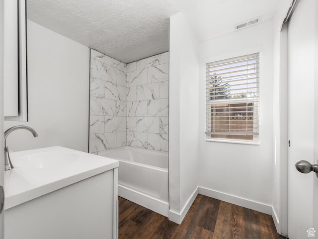 250 N 100 E, Tooele, UT 84074 - full bath featuring baseboards, wood finished floors, vanity, a textured ceiling, and bathtub / shower combination