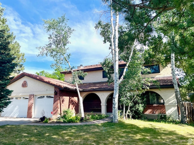 1922 E Southbridge Way, Sandy, UT 84093 - mediterranean / spanish-style home with a front lawn, stucco siding, a tiled roof, an attached garage, and brick siding