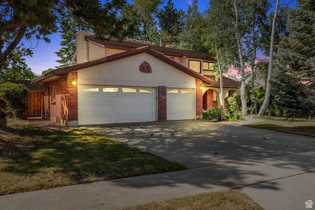 1922 E Southbridge Way, Sandy, UT 84093 - mediterranean / spanish home featuring an attached garage, concrete driveway, brick siding, and stucco siding