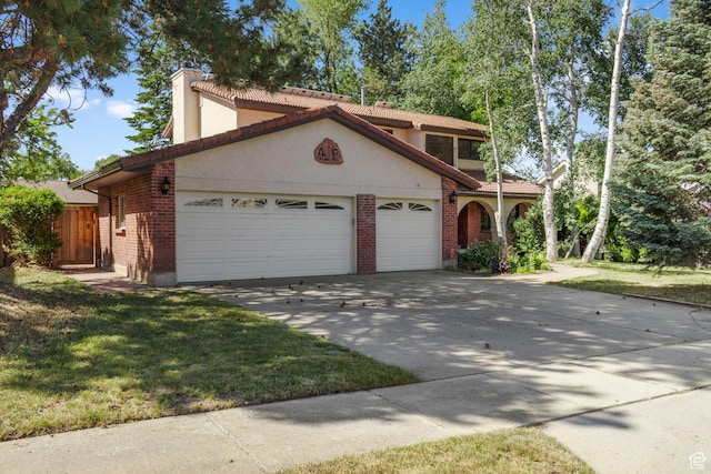 1922 E Southbridge Way, Sandy, UT 84093 - mediterranean / spanish house featuring a garage, concrete driveway, a chimney, and brick siding