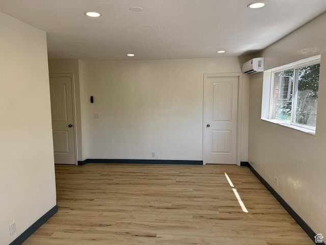559 E Harmston Ave, Roosevelt, UT 84066 - spare room featuring a wall mounted AC, baseboards, light wood-style flooring, and recessed lighting