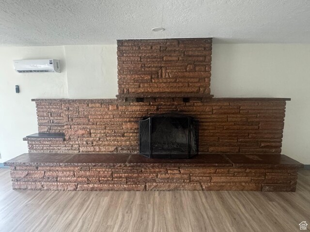 559 E Harmston Ave, Roosevelt, UT 84066 - detailed view of a wall unit AC, wood finished floors, a brick fireplace, and a textured ceiling