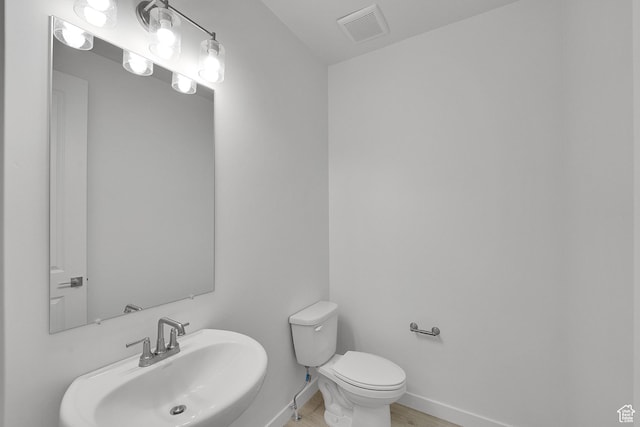 1147 N 375 W Unit 11, Harrisville, UT 84404 - half bathroom featuring a sink, toilet, baseboards, and wood finished floors