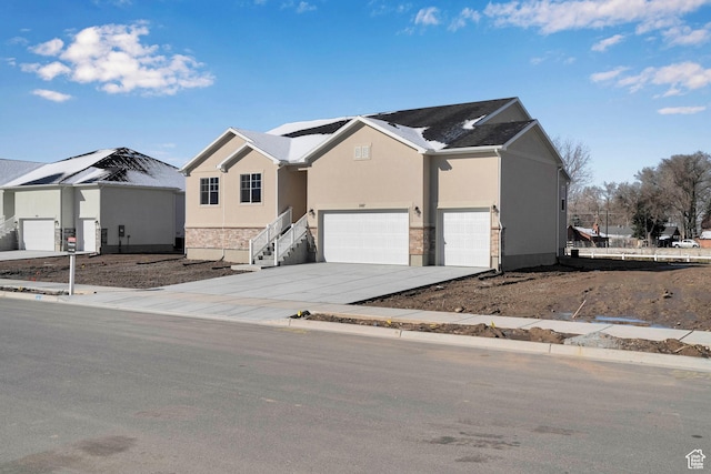 1147 N 375 W Unit 11, Harrisville, UT 84404 - view of front of property with an attached garage, concrete driveway, stucco siding, and stone siding