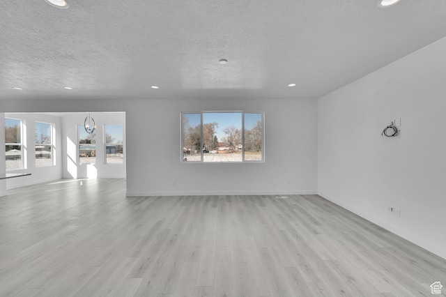 1147 N 375 W Unit 11, Harrisville, UT 84404 - unfurnished living room featuring a textured ceiling, light wood-type flooring, recessed lighting, and baseboards