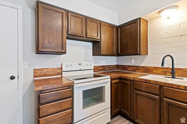 190 W 1100 N, Logan, UT 84341 - kitchen with white electric range oven, a sink, and butcher block counters