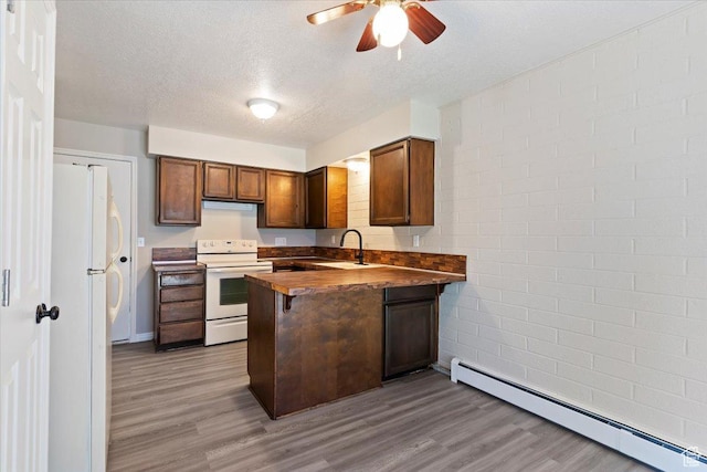 190 W 1100 N, Logan, UT 84341 - kitchen featuring white appliances, a baseboard heating unit, a peninsula, a ceiling fan, and wood finished floors
