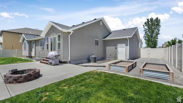 1026 E Searle Ln, Eagle Mountain, UT 84005 - back of house featuring an outdoor fire pit, a patio, a vegetable garden, central AC unit, and stucco siding