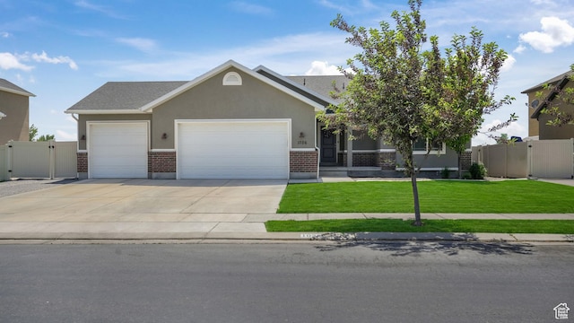 1026 E Searle Ln, Eagle Mountain, UT 84005 - view of front of home with a garage, brick siding, a gate, and driveway