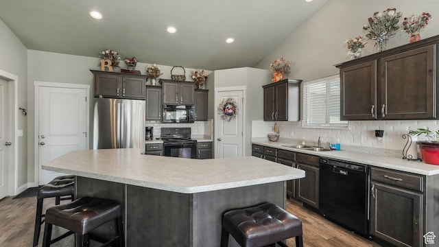 1026 E Searle Ln, Eagle Mountain, UT 84005 - kitchen featuring black appliances, a breakfast bar, wood finished floors, tasteful backsplash, and a sink