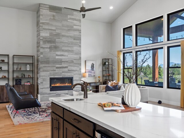 4021 E 4325 N, Eden, UT 84310 - kitchen featuring a sink, high vaulted ceiling, open floor plan, a large fireplace, and light wood-type flooring