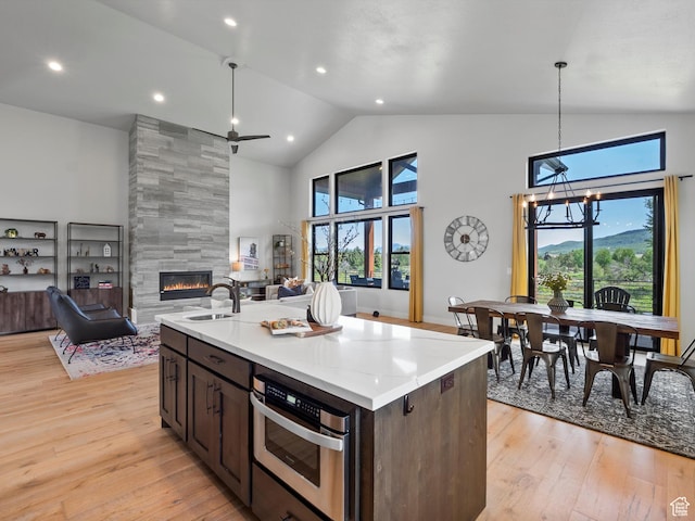 4021 E 4325 N, Eden, UT 84310 - kitchen with a tile fireplace, oven, high vaulted ceiling, open floor plan, and light wood-style flooring