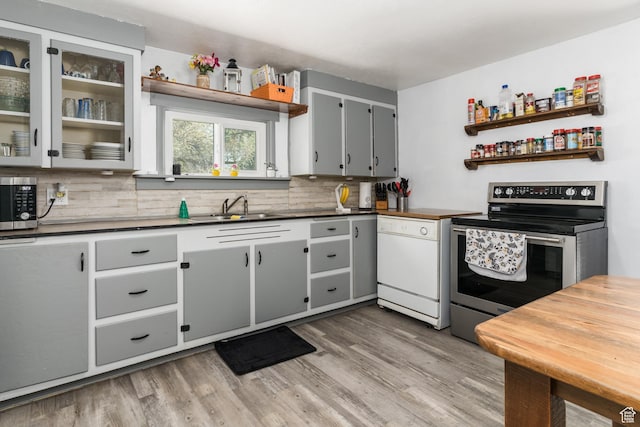 220 S 2nd E, Soda Springs, ID 83276 - kitchen with appliances with stainless steel finishes, open shelves, tasteful backsplash, and light wood-style flooring
