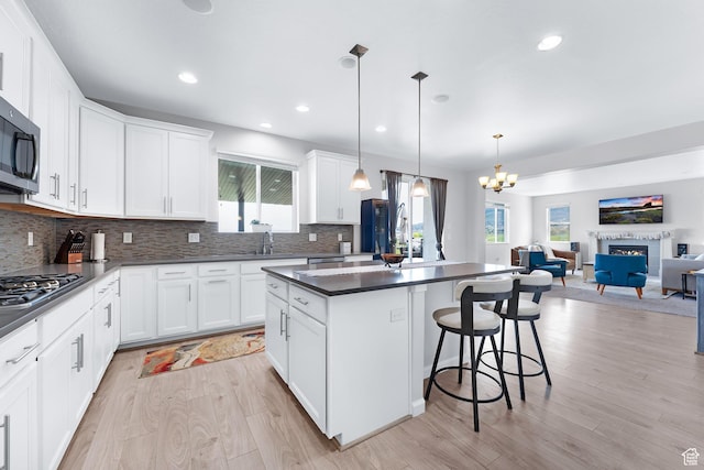 227 E Sandhill Dr, Saratoga Springs, UT 84045 - kitchen with dark countertops, appliances with stainless steel finishes, a sink, light wood-type flooring, and recessed lighting