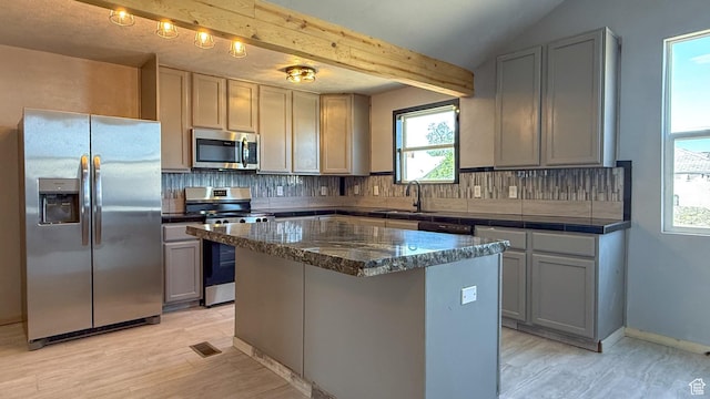121 2nd W, East Carbon, UT 84520 - kitchen featuring stainless steel appliances, decorative backsplash, a center island, gray cabinets, and beam ceiling