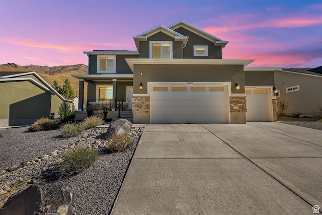 8498 N Colette St, Lake Point, UT 84074 - view of front facade with stone siding, a porch, stucco siding, and concrete driveway