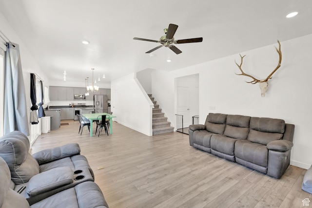 8498 N Colette St, Lake Point, UT 84074 - living room with light wood finished floors, recessed lighting, a ceiling fan, baseboards, and stairway