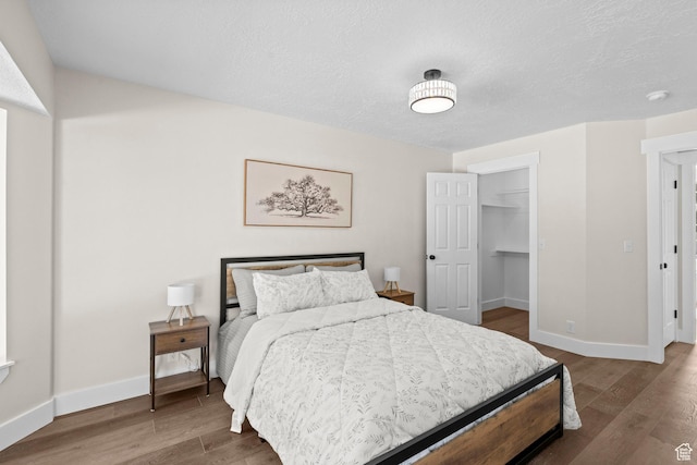 2139 N 300 W, Lehi, UT 84043 - bedroom with wood finished floors, baseboards, a walk in closet, a textured ceiling, and a closet