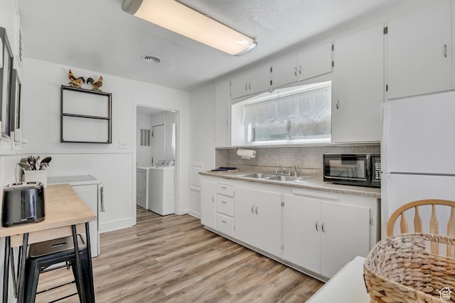 232 E 5900 S, Murray, UT 84107 - kitchen featuring black microwave, freestanding refrigerator, a sink, washing machine and dryer, and light countertops