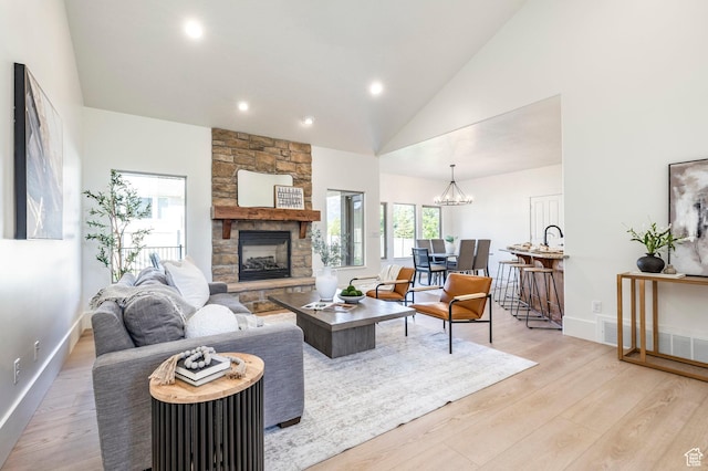 5865 Belmont Dr, Mountain Green, UT 84050 - living room with a stone fireplace, light wood-style floors, recessed lighting, a chandelier, and high vaulted ceiling