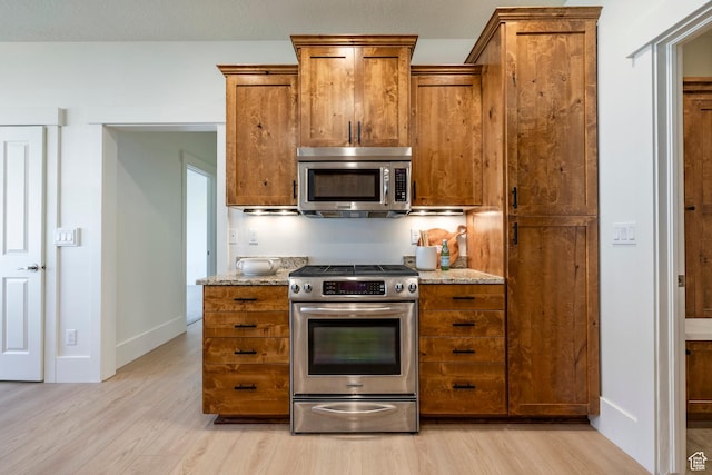 5865 Belmont Dr, Mountain Green, UT 84050 - kitchen with appliances with stainless steel finishes, brown cabinetry, and light wood finished floors
